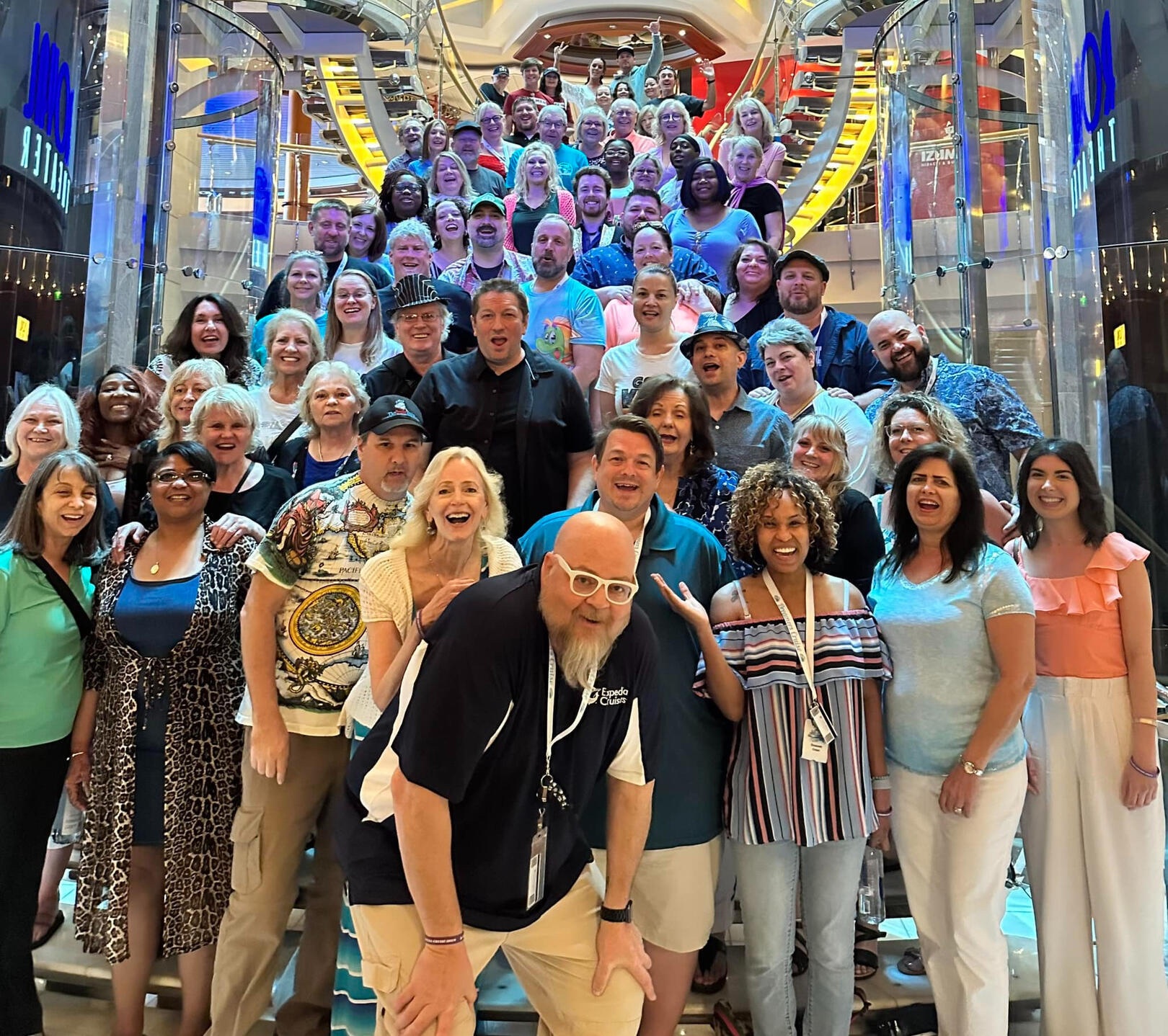 A large Dreamers Cruise group gathered on a ship's grand staircase